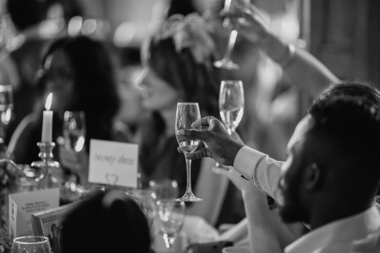 Black and white photo of people toasting the newlyweds.